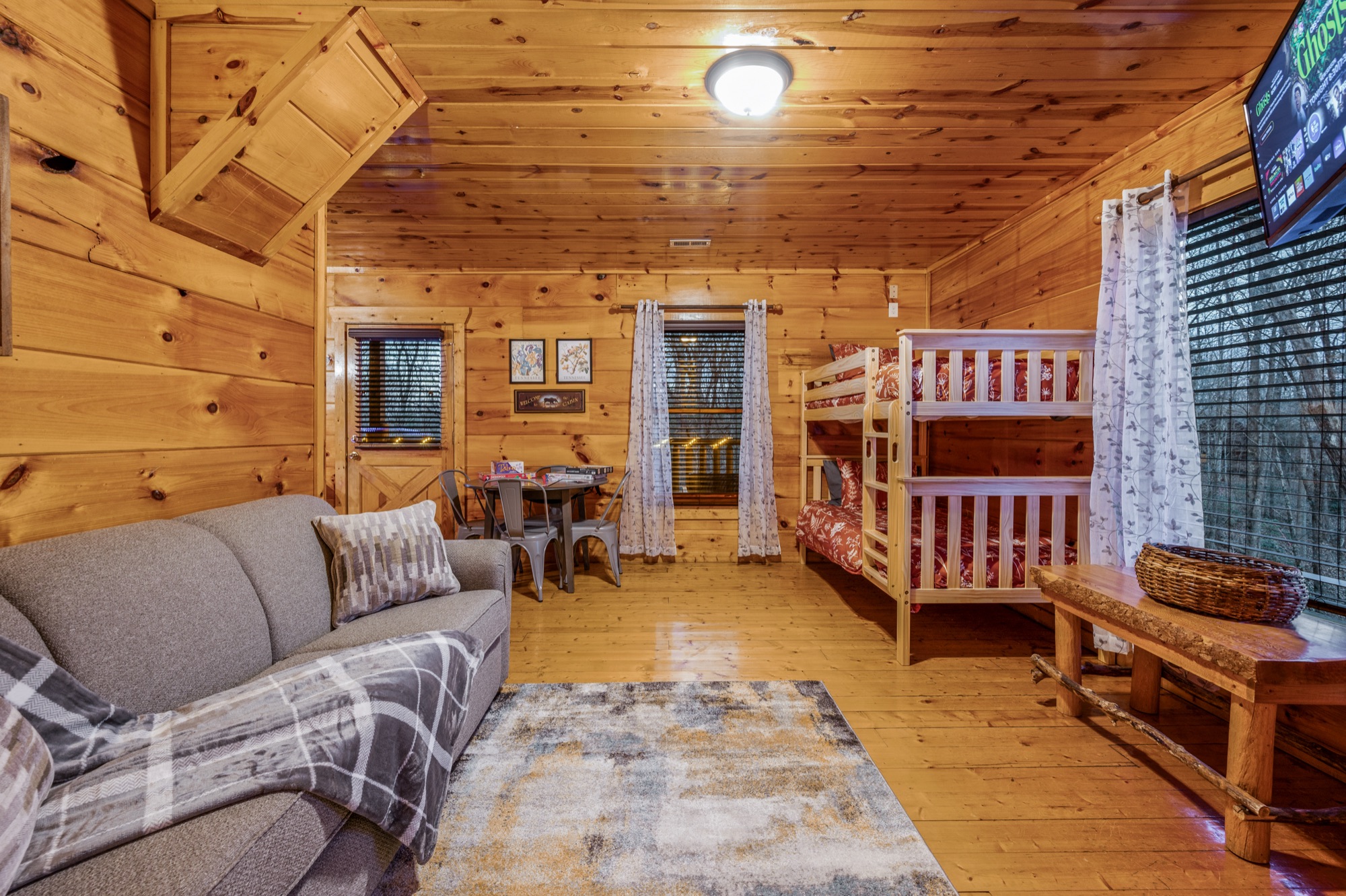 Bearadise bunk room with a sleeper sofa and a full over full bunk bed
